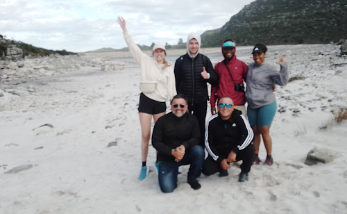 A group of hikers on the beach, Table Mountain. 